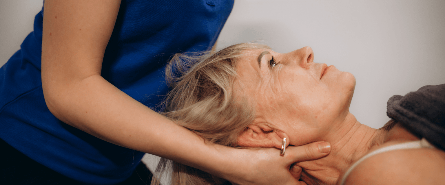 integrative medicine practitioner massages neck of woman